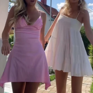 Ljusrosa kortklänning med smala axelband - Säljer en söt ljusrosa kortklänning med smala axelband och v-ringning. Klänningen har en figurnära passform upptill och lätt utsvängd kjol. Perfekt för sommarens tillfällen! Osäker på storleken då det inte finns någon lapp, men passar xs/s. 