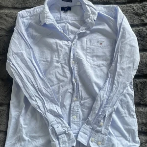 Ljusblå Gant skjorta - Säljer nu min Gant skjorta som är för liten! | Storlek 158/164, motsvarar ungefär XXS. | Väldigt bra skick utan några som helst fläckar. | Släng iväg en signal vid funderingar så svarar jag snabbt. |