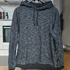 Mörkgrå hoodie från H&M - Säljer en mörkgråmelerad hoodie från H&M i regular fit. Tröjan har huva med dragsko och långa ärmar.