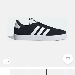 Svarta Adidas sneakers med vita ränder - Använd 2 gånger och har bytt till vita skosnören. Klassiska svarta Adidas sneakers med vita ränder på sidorna och vit sula. Skorna har snörning och en låg profil, perfekt för en stilren vardagslook. Materialet ser ut att vara syntet och mocka.