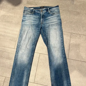 Blå jeans från Jack & Jones Regular Fit Clark - Säljer ett par klassiska blå jeans från Jack & Jones, modell Regular Fit Clark. Jeansen har fem fickor, normal passform och raka ben.