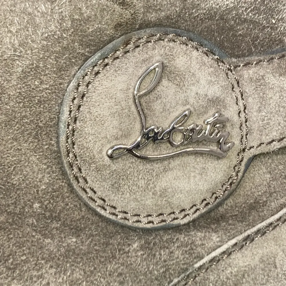 Säljer ett par grå höga sneakers från Christian Louboutin i mocka med snörning och spänndetaljer. Skorna har rund tå, vit platt sula och diskret logga på sidan. Perfekta för dig som vill ha något unikt och stilrent.. Kengät.