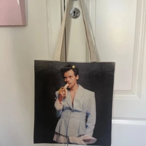 Harry Styles tygkasse - Tygkasse i beige med Harry Styles på, köpt i en butik i Köpenhamn. Aldrig använd men har en liten fläck på baksidan, lite som en dammfläck. Annars i mycket bra skick. 