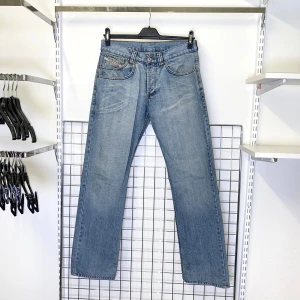 Diesel ljusblå jeans - Ett par klassiska ljusblå jeans från Diesel med raka ben och knappgylf. Jeansen har fem fickor och diskreta sömmar på bakfickorna.  Strl: W32. Mått: Innerbenslängd 85 cm.   /  Spara skärmtid, besök våra butiker i Sthlm, Malmö & Gbg. New arrivals daily + studentrabatt i alla våra butiker! Hitta till din närmsta butik på humansecondhand.se.   HUMANA Second Hand erbjuder 14 dagars retur, även via plick. Returer skickas med PostNord. Vid retur kontakta support@plick.se.
