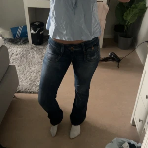 Mörkblå jeansbyxor - Säljer ett par mörkblå jeansbyxor med normal passform och raka ben. Byxorna har klassiska fickor fram och bak samt knäppning med dragkedja och knapp. Perfekta till vardags och enkla att matcha med olika toppar. Säljer pga för långa för mig.