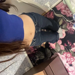 Lågmidjade Mörkblåa jeansbyxor från Gina tricot - Säljer ett par mörkblå jeansbyxor från Gina tricot i klassisk modell. Byxorna har normal passform och raka ben, med snygga kontrastsömmar och femficksdesign. Perfekta till många olika outfits!