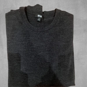 Grå merinoull tröja från Uniqlo - Säljer en stilren grå merinoull tröja från Uniqlo i storlek XS. Tröjan är knappt använd och har inga defekter.