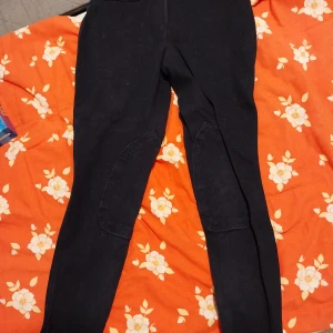 Svarta ridbyxor från Mountain Horse - Säljer ett par svarta ridbyxor från Mountain Horse. Byxorna har förstärkta partier på insidan av benen och är perfekta för ridning. Klassisk design med normal passform och bekväm midja. 300 kr