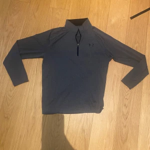 Grå tröja från Under Armour - Mycket bra skick, passar mig som är M lika bra som L