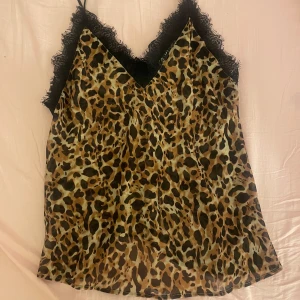 Leopardmönstrad linnetopp från MNG - Snygg leopardmönstrad linnetopp från MNG med spetsdetaljer vid halsringningen. Rätt så genomskinlig men märks inte mycket om man har t.ex svart bh under, luftigt material och perfekt för sommaren