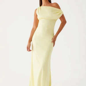 Ljusgul balklänning - Elegant ljusgul långklänning med en stilren oneshoulder-design. Perfekt för en somrig fest eller bal. Klänningen har en smickrande passform som framhäver figuren. Prislapp kvar. Nypris 1400kr