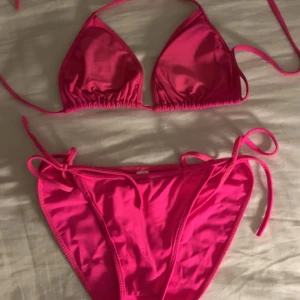 Rosa bikini med knytband - Snygg rosa bikini med trekantsöverdel och knytband i sidorna. Perfekt för soliga dagar på stranden eller vid poolen. Enkel och stilren design som ger en klassisk look.💕