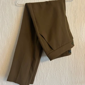 Grön/bruna kostymbyxor - Så sjukt snygga byxor. Säljer pga av för stora för mig. Ytterst sparsamt använda.