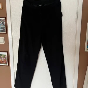 Svarta kostymbyxor - Snygga svarta kostymbyxor med en klassisk rak passform. Byxorna har en hög midja och är perfekta för en stilren look. Använda några gånger men är i fint skick. 