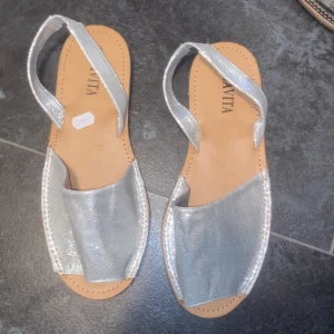 Silvriga sandaler från Savita - Snygga silvriga sandaler från Savita med öppen tå och remmar. Perfekta för sommarens varma dagar. Lätta att matcha med olika outfits. Oanvända, nypris 299