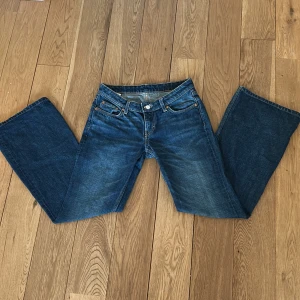 Blå jeans från Weekday - Snygga blå jeans från Weekday med en klassisk femficksdesign. De har en slim bootcut-stil och är tillverkade i ett slitstarkt denimtyg. Perfekta för en avslappnad look.