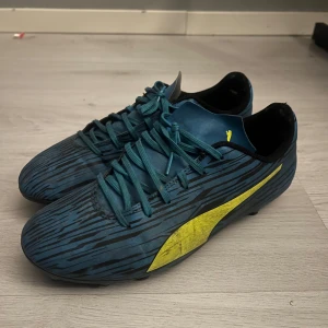 Blå och gula fotbollsskor från Puma - OBS* som ni ser på fjärde bilden så finns det som en öppning under skorna men det skulle man kunna ta super lim och lägga tillbaks den men den fungerar att spela med så också storlek lek:44