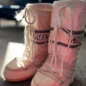 Vita Moon Boots med snörning - Säljer ett par klassiska vita Moon Boots med snörning. Perfekta för kalla vinterdagar med sin unika design och varma foder. De har en hög och vadderad stil som ger både komfort och stil. Passar utmärkt för vinteraktiviteter.