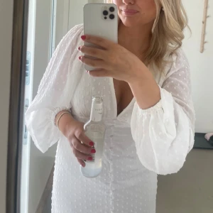 Vit klänning med v-ringning - Lång vit klänning med ballongärmar. Använd en gång så som ny!  Storlek s. 