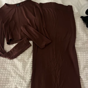 Ett brunt kjol sett - Snygg brun långklänning med matchande långärmad topp.