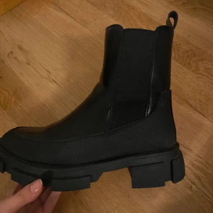 Svarta chelsea boots - Snygga svarta chelsea boots med grov sula och elastiska paneler på sidorna för enkel på- och avtagning. Perfekta för en stilren look.