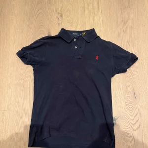 Ralph lauren piké  - Säljer denna feta Ralph lauren piken som är perfekt nu när det börjar närma sig lite varmare väder. Tröjan är i ett bra skick då den använts sparsamt. Den är i storlek 14-16 och passar dig som är mellan 160-170. Skriv vid minsta fundering eller fråga. 