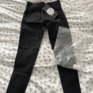 Svarta leggings från ICANIWILL - Snygga svarta leggings från ICANIWILL med hög midja och ribbad detalj vid midjan. Perfekta för träning med en tight passform som ger bra stöd. Materialet är stretchigt och bekvämt.