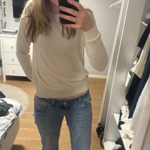 Beige långärmad tröja - Säljer en stilren beige tröja. Perfekt för en avslappnad look. Tröjan har en enkel design och är lätt att matcha med olika outfits. Tröjan har även ett litet hål och en liten fläck 🫣skriv om ni vill ha fler bilder!!!