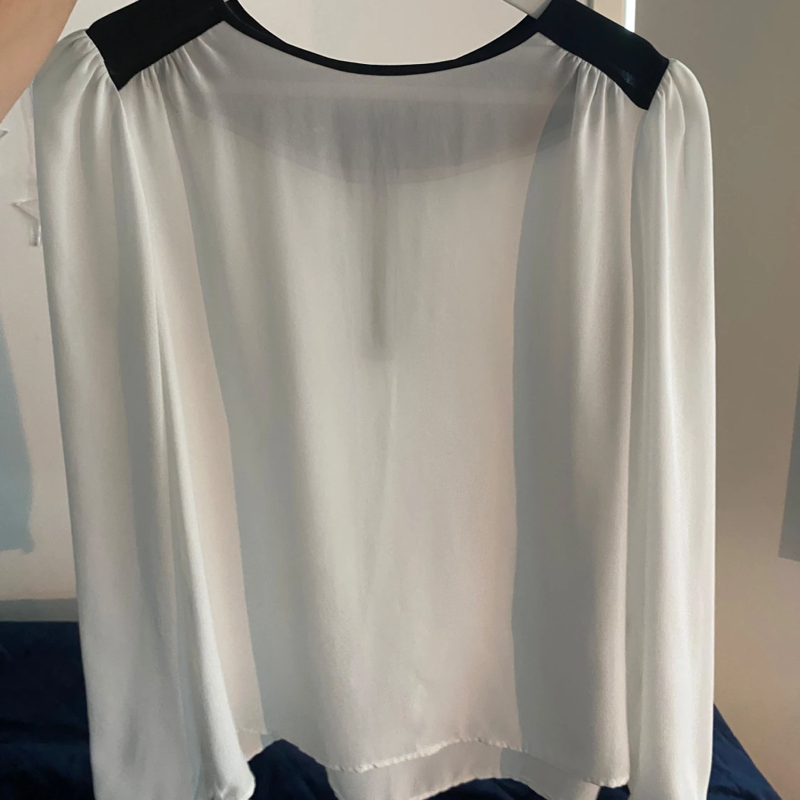 Vit blus med svarta detaljer och dragkedja