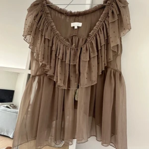 Beige volangblus  - Superfin beige blus från Buch Copenhagen med flera lager volanger och små pärldetaljer. 