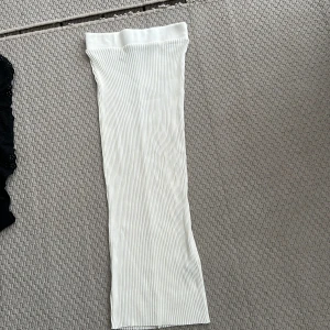 Vit ribbad långkjol S - Säljer en vit långkjol med ribbad struktur. Kjolen är rak i modellen och har en clean, minimalistisk look som passar perfekt till sneakers eller boots. Storlek S från Zara. Super strech. 