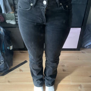 Bootcut jeans i svart från 157, XXS - Svarta bootcut jeans från Lager 157 i modellen 90's Boot. Låg midja, klassiska femficksdetaljer och snygga bakfickor med lock och knapp. Jeansen är i stretchig bomullsblandning och har en rak men utsvängd passform nertill. Perfekta för dig som gillar retrovibbar.