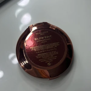 Revolution Pro Glow Edit Cream Bronzer - Glow Edit Cream Bronzer från Revolution Pro i färgen Bronze. Kommer i en snygg, rund, roséguldig dosa med spegel. Perfekt för att skapa en solkysst look och ge ansiktet extra dimension. Innehåller 4g krämig bronzer som är lätt att blenda.