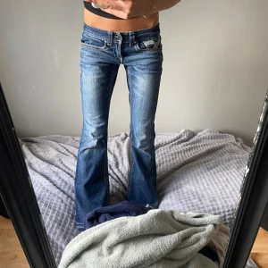 Mörk blå botcut jeans - Snygga blå bootcut jeans med låg midja och coola broderade bakfickor med pärldetaljer. Jag köpte de här byxorna på Plick men de va tyvärr försmå för mig så jag säljer vidare dem. Första bilen är från den jag köpte de från.🩷Den jag köpte de från sa att de va S men jag skulle säga att de är mer Xxs till Xs för referens är jag 155.