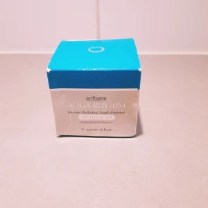 Oriflame Aqua-Rhythm Night Cream - Oriflame Aqua-Rhythm Intense Hydration Youth Preserve Night Cream med Hydro-Protect Complex. Kommer i en rund glasburk med blått plastlock, 50 ml. Förpackningen är blå och silverfärgad och innehåller även en informationsbroschyr.  Ny så inget att anmärka på