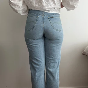 Ljusblå Lee jeans - Ljusblå Lee jeans med medelhög midja! Hon som har på sig dom är 168cm lång, knappt använda🤍 Strl - W27 L35