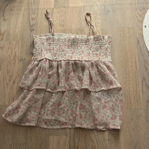 Blommig volangtop från Gina Tricot -  blommig linnetopp från Gina Tricot med volanger.