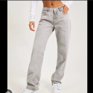 Gråa jeans från Gina  - Säljer ett par jätte snygga ljusgråa jeans med rak passform och lågmidjade från Gina. Perfekta för en avslappnad och trendig look.