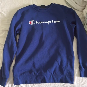 Blå Champion sweatshirt X-Large barn storlek - Säljer en klassisk marinblå sweatshirt från Champion i storlek X-Large. Tröjan har lång ärm, rund halsringning och stor broderad Champion-logga framtill. Perfekt för dig som gillar sportig och avslappnad stil.