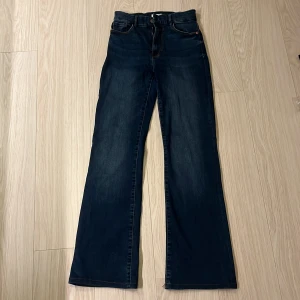 Mörkblå bootcut jeans från Lindex - Snygga mörkblå jeans från Lindex i bootcut-modell med klassiska fickor. Samt hög midja och tillverkade i mjukt denimtyg som sitter skönt hela dagen. Längst ner på byxorna har sömmen gått upp lite men det är ingenting man märker! 