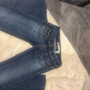 LOW WAIST ONLY JEANS  - Snygga blå jeans från ONLY med klassisk femficksdesign och slitna detaljer. Jeansen har normal passform, bootcut och coola kontrastsömmar. Perfekta till sneakers eller boots och funkar året runt. Materialet är tåligt denim i bomull. Har endast används fåtal och är i bra kondition.