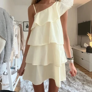 Ljusgul one shoulder volangklänning - Helt oanvänd, storlek 170 vilket motsvarar storlek S! Lånad bild då klänningen ligger i orginalförpackning