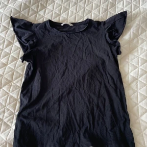 Svart T-shirt från Mango - Säljer en svart tröja med volangärmar från Mango. Pris går att diskutera☺️