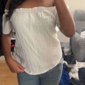 Vit offshoulder topp - Säljer en vit offshoulder topp med korta ärmar och snyggt strukturerat tyg. Passar till allt och skönt material.
