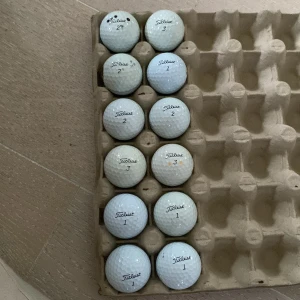 Fina golfbollar - Bilderna visar ett dussin begagnade Titleist Pro V1 golfbollar i en äggkartong. Perfekt för dig som vill spela golf utan att spräcka budgeten! Bollarna har olika nummer , men är redo för nya rundor på banan.