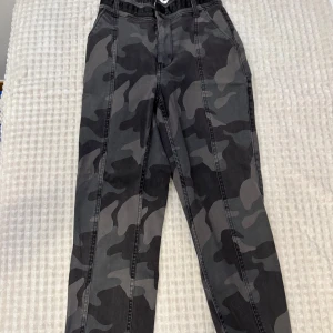 Camo cargopants från Hollister XS - Snygga cargopants från Hollister i camomönster med svarta och grå toner. Byxorna har ultrahög midja och muddar vid bensluten. Aldrig använda. Storlek xs