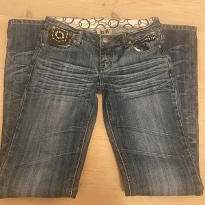 Blå bootcut jeans med detaljer - Snygga blå bootcut jeans från just play med slitningar och coola detaljer på fickorna. Låg midja och dekorativa broderier på bakfickorna. Jeansen har klassisk femficksdesign och är tillverkade i stretchig denim för skön passform. Hör av er vid frågor och priset kan diskuteras ❤️❤️
