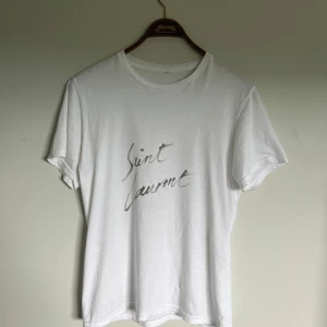Saint Laurent t shirt - Riktigt fet och eftertraktad Saint Laurent t shirt i mycket bra skick! Är lite osäker på äktheten så därför är priset just nu på 1299kr! nypris runt 4000kr. Storlek S. Tveka inte med att ställa frågor!