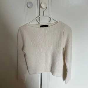 stickad tröja - Supermjuk ljusbeige/vit stickad tröja från mango med ribbad struktur. Tröjan har lång ärm och en enkel, rak passform som är lätt att matcha med allt. Perfekt för lager-på-lager under kyliga dagar.