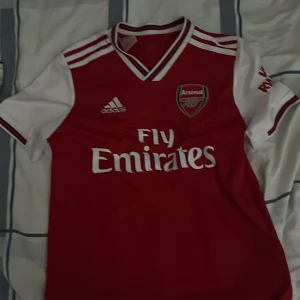 Arsenal Adidas röd/vit matchtröja  OBS köparen står för frakt  - Riktigt fin Arsenal tröja de är L i barn storlek så de står på den 13-14y väldigt bra skick knappat använd. Köparen står för frakt. Kan mötas upp i centrala Göteborg 